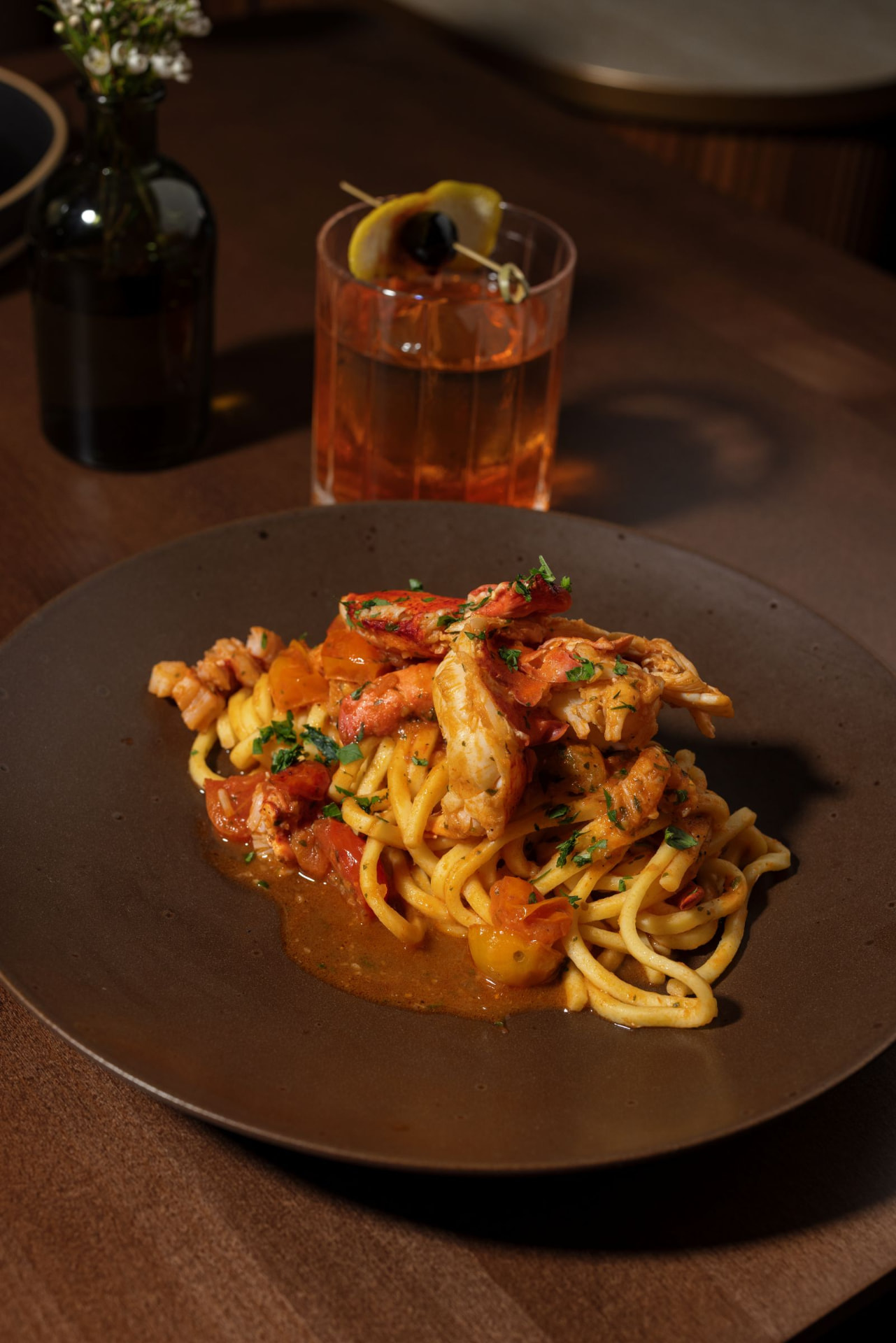 Lobster tonnarelli in a rich tomato-lobster sauce on a handmade pasta plate