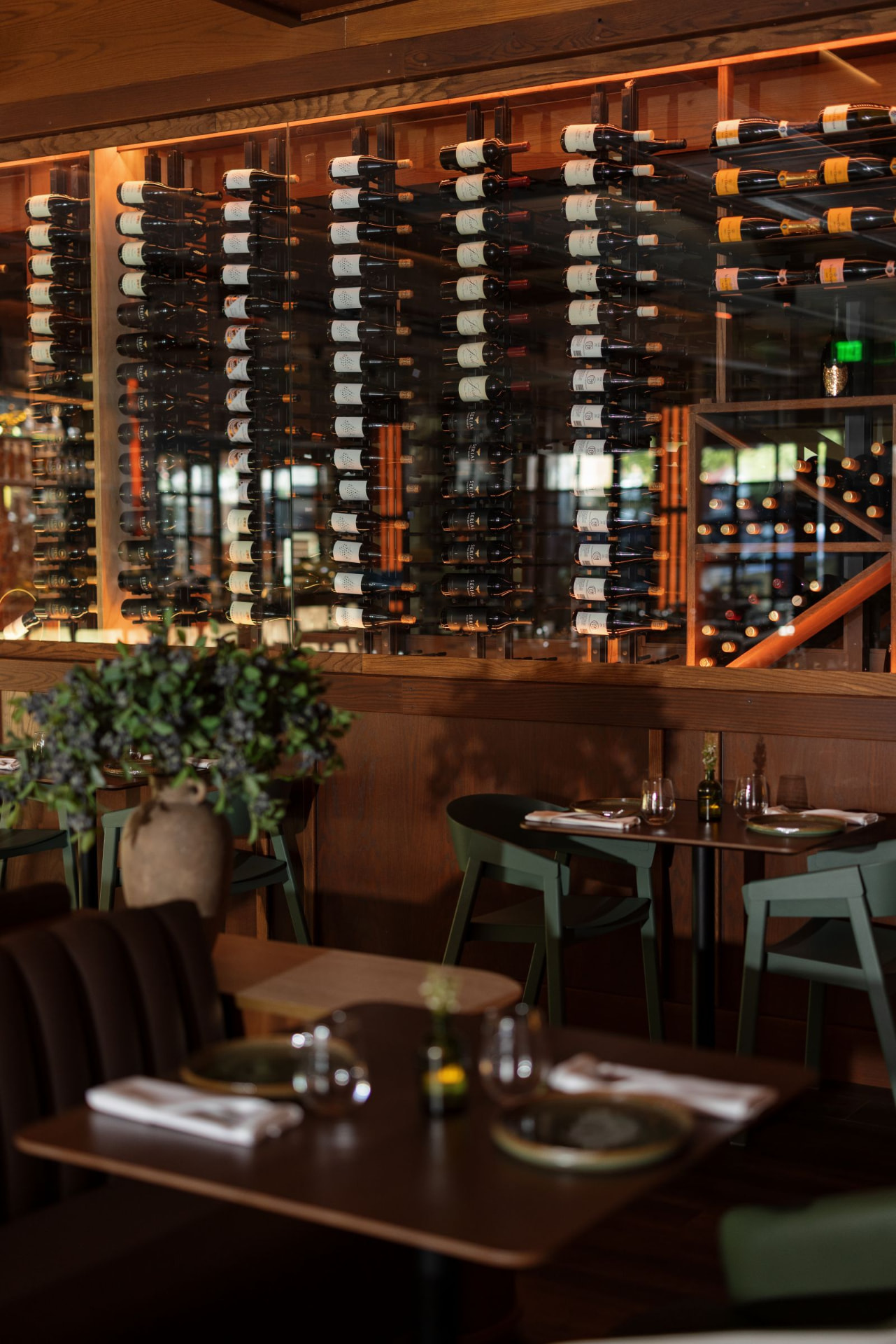 Candlelit dining tables set beneath the floor-to-ceiling wine wall at The Social